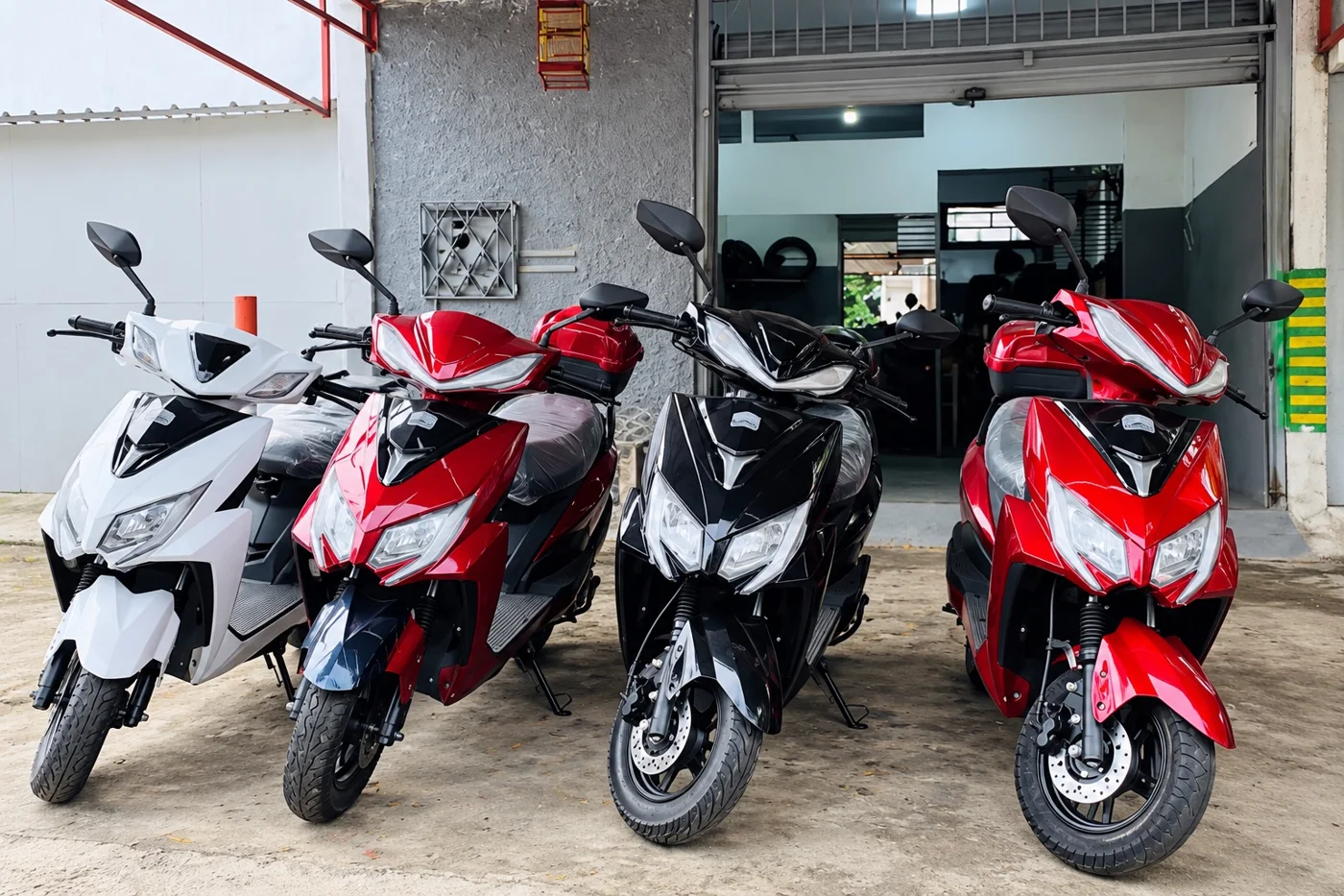 Scooters de diferentes cores em frente à oficina